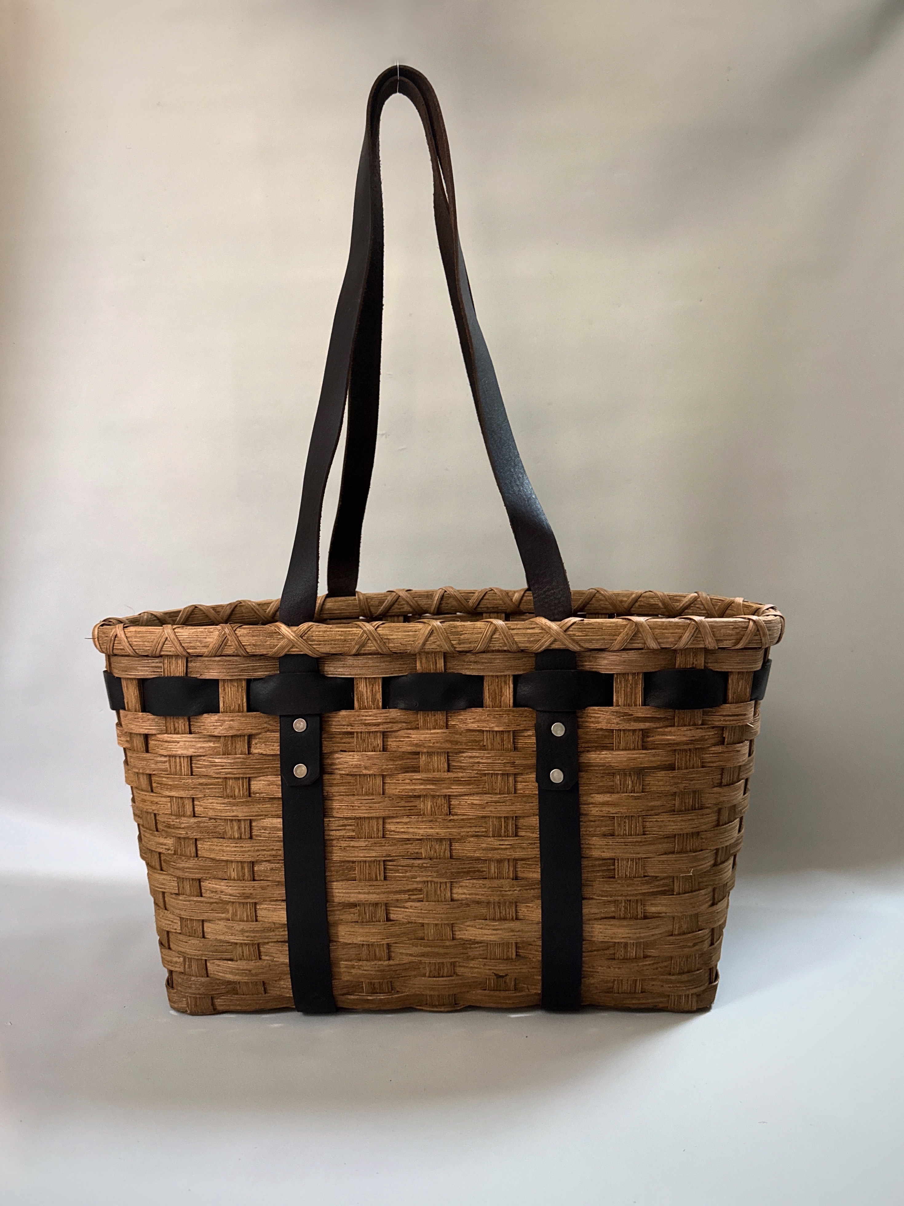 Shoulder Leather Handled Tote, an oval reed basket with long leather shoulder straps